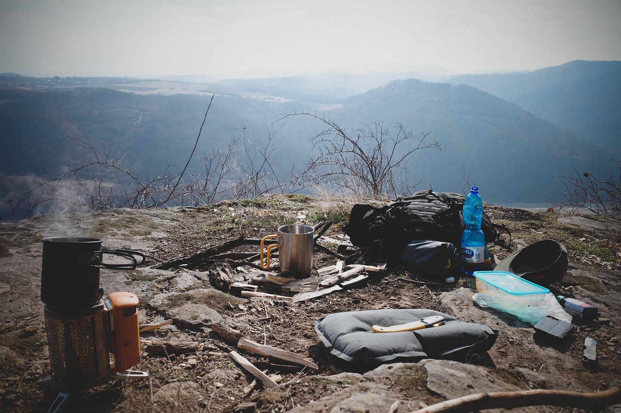 Astronomy camp gear including a red headlamp, binoculars, and a thermos on a table