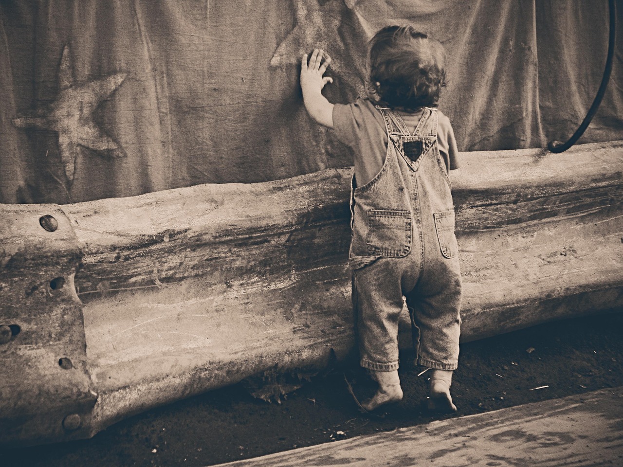 Young child sitting on a rug playing with a colorful set of wooden building blocks