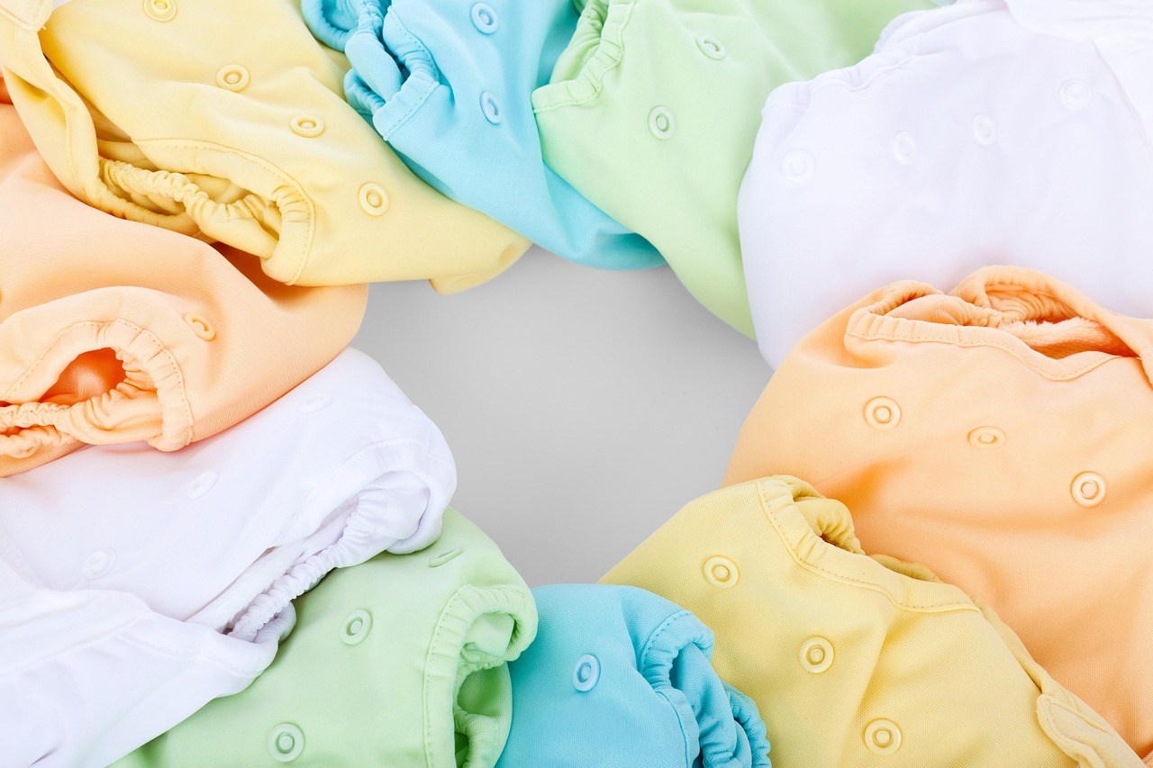 A baby wearing a pocket cloth diaper with an adjustable snap fit.