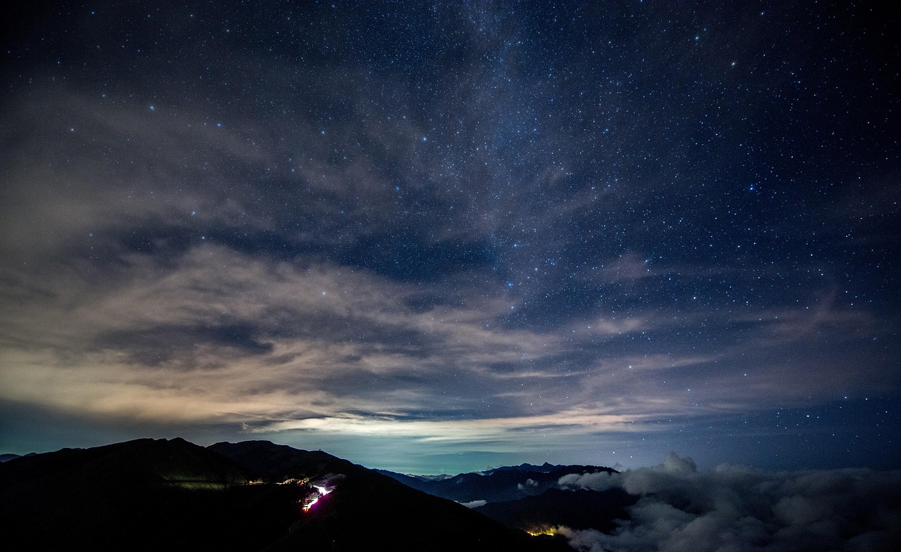An expansive view of a dark sky park with stars above and a serene landscape below