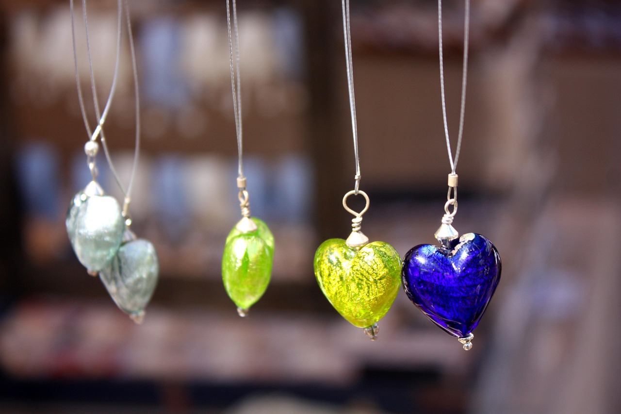 Handmade recycled silver earrings and pendant displayed on a wooden surface