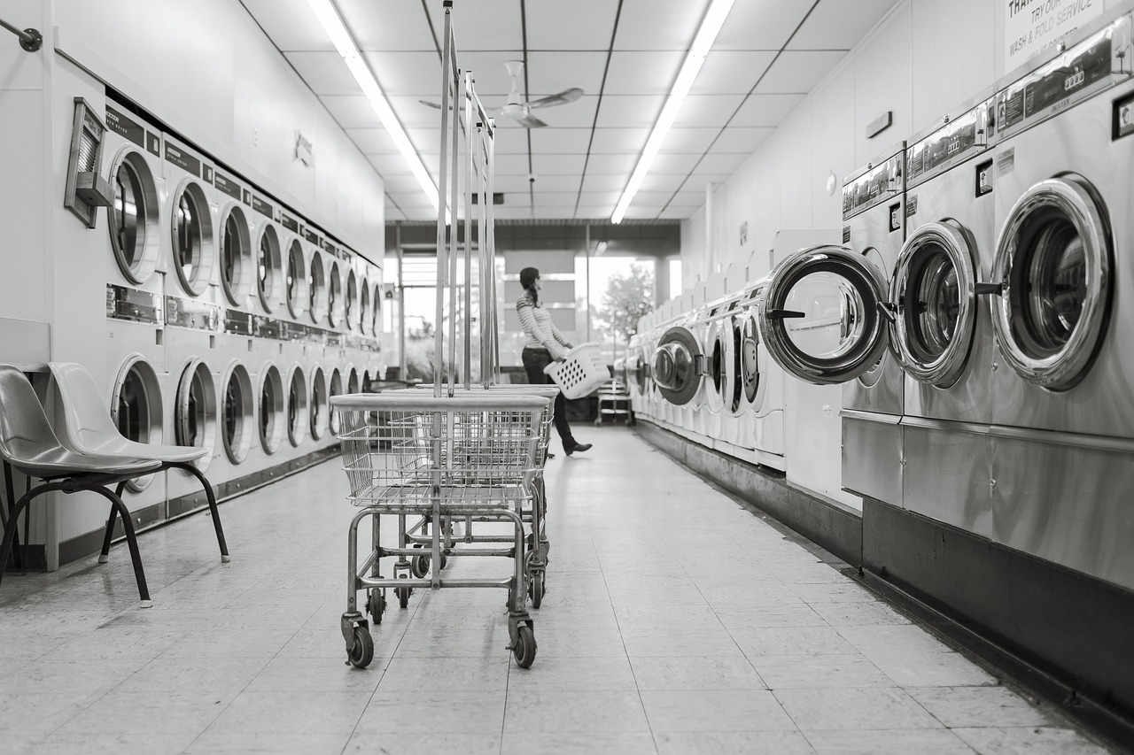 Hands placing eco-friendly laundry detergent strips into a washing machine