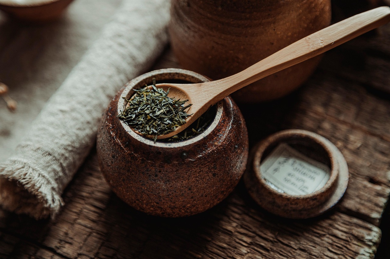 Loose leaf tea in a glass jar with metal lid on a wooden table
