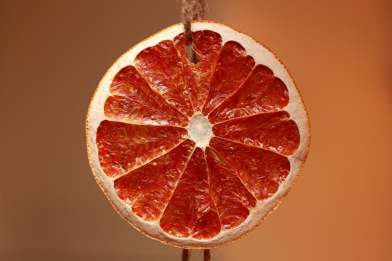 A natural twine knot on a fabric-wrapped gift with a dried orange slice tucked underneath