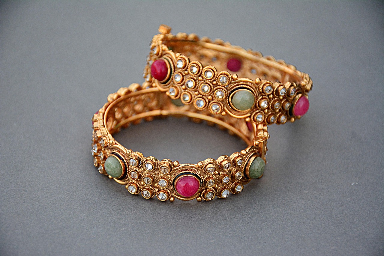 A single handmade recycled brass bangle bracelet on a neutral background