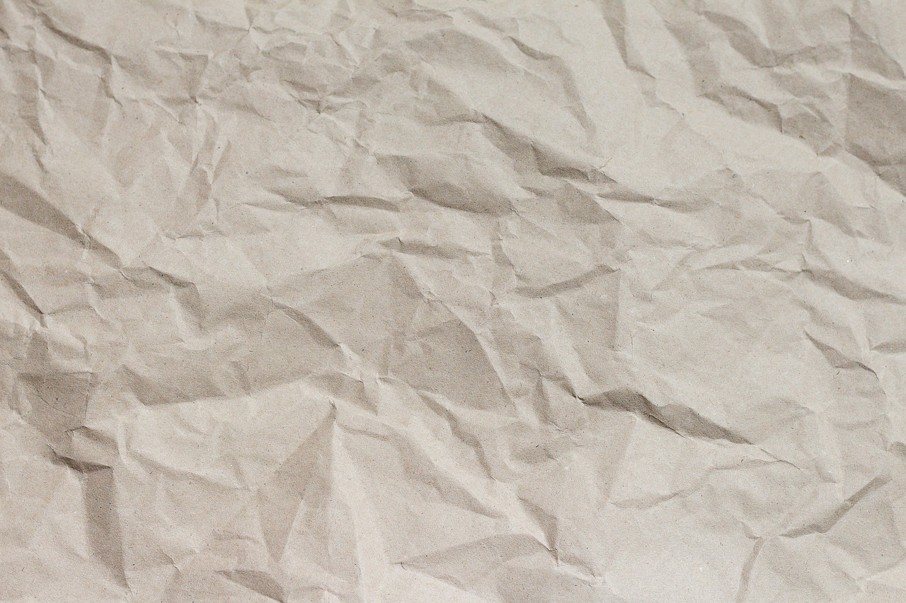 A recycled kraft paper gift wrap kit with natural twine spool on a wooden table