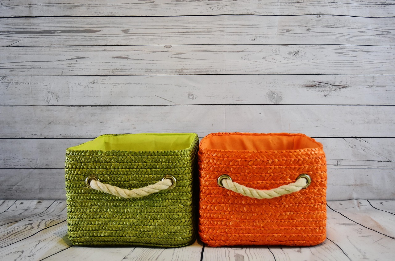A large seagrass basket used for storing blankets in a room with natural decor accents