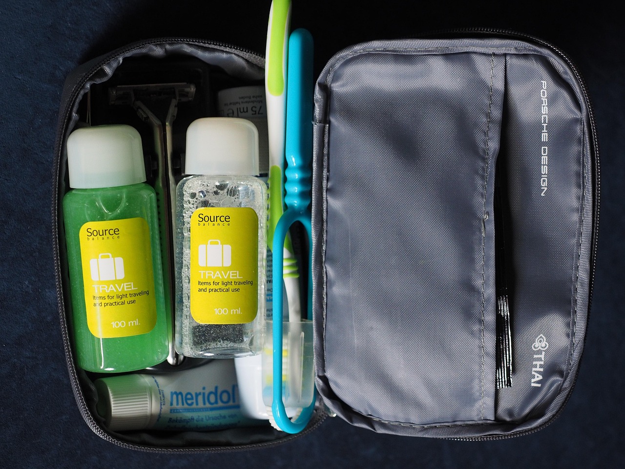 A portable travel tin for storing a shampoo bar with built-in drainage