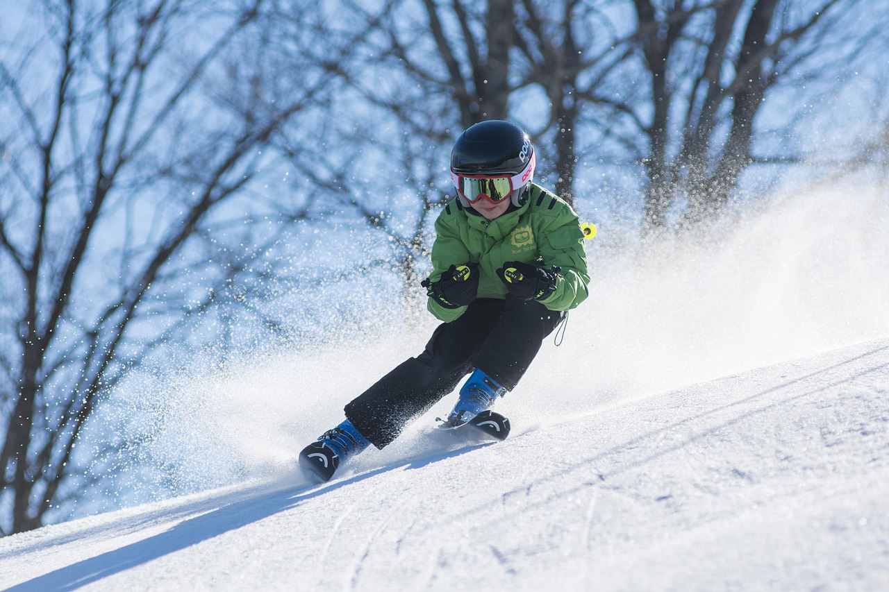 ski gear essentials like helmet goggles gloves and base layers laid out on a table