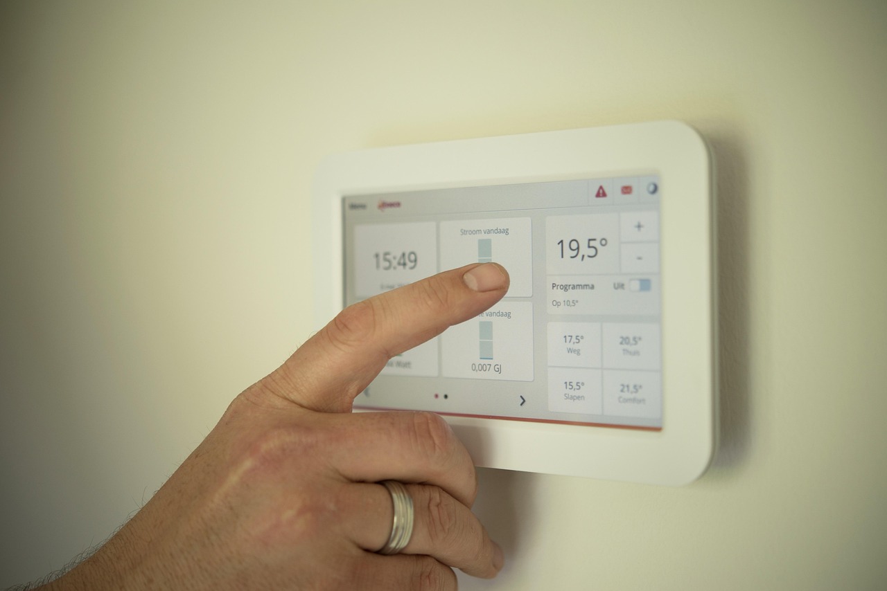 A modern smart thermostat mounted on a wall with a digital display