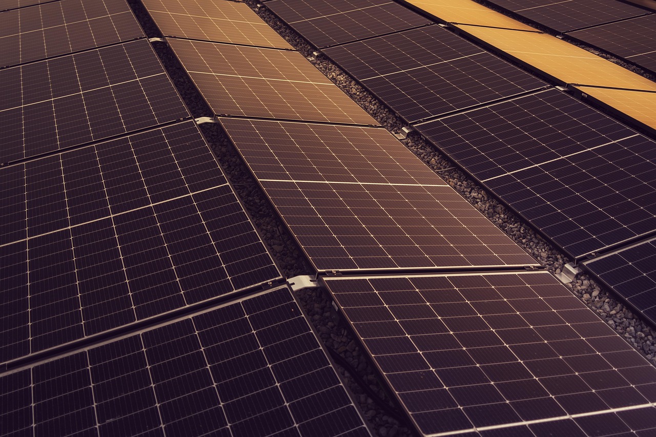 A foldable solar panel charging a smartphone on a hiking trail in bright sunlight