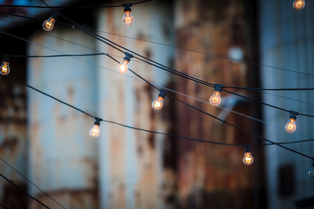 Warm solar string lights illuminating a wooden patio at dusk