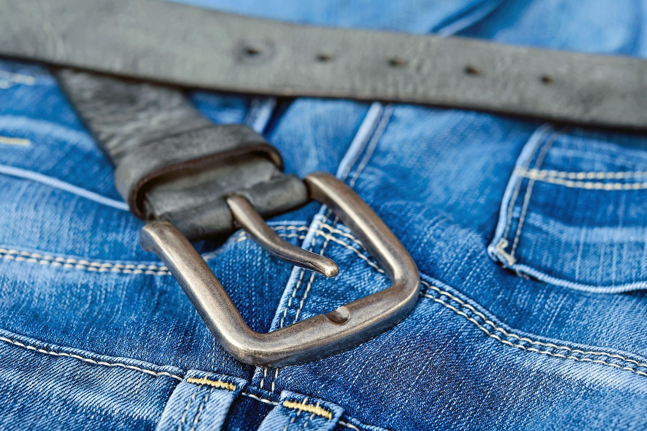 Close-up of a solid brass belt buckle on a leather belt