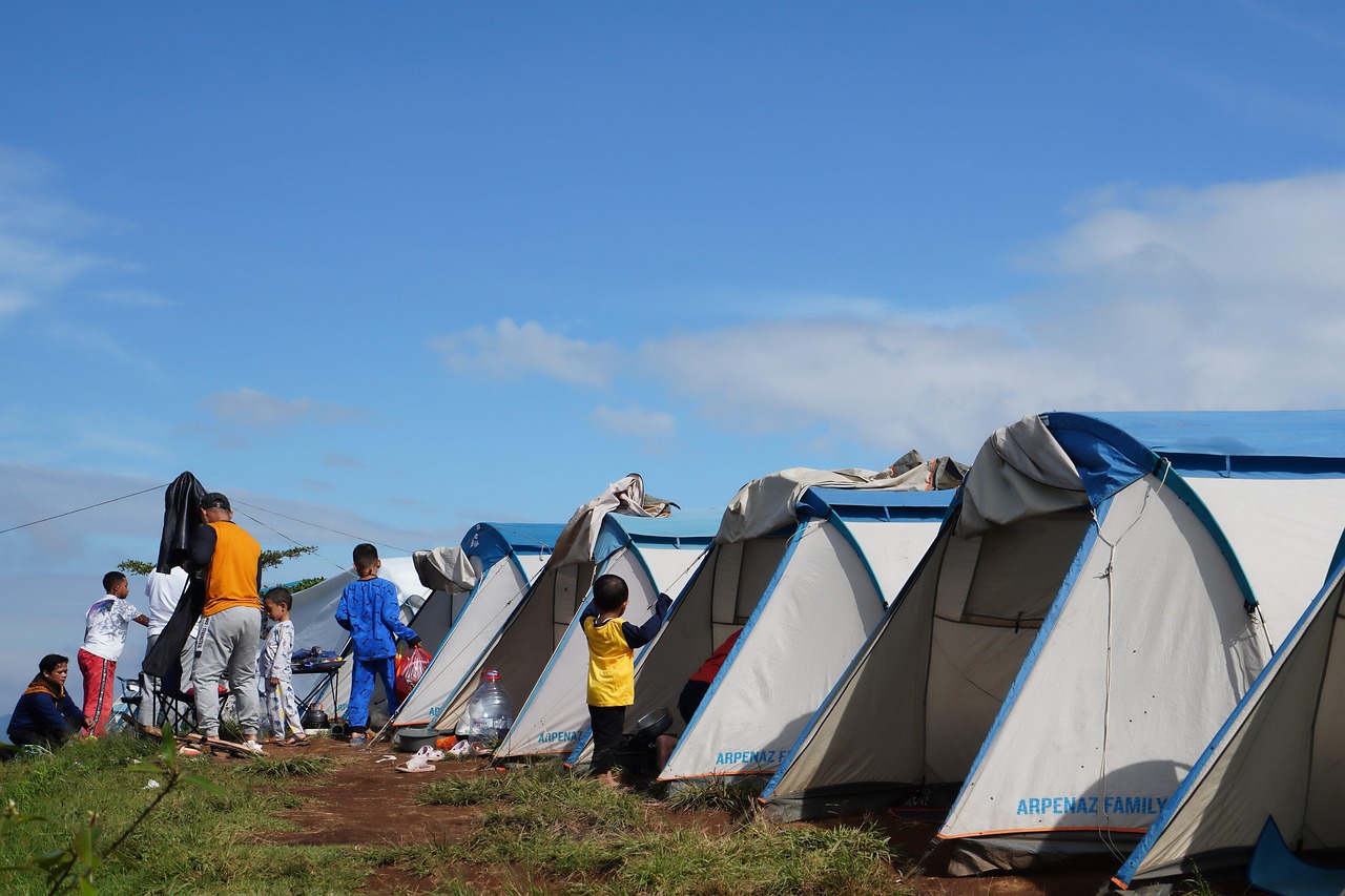 Teenagers gathered around a telescope at an astronomy camp under a dark sky