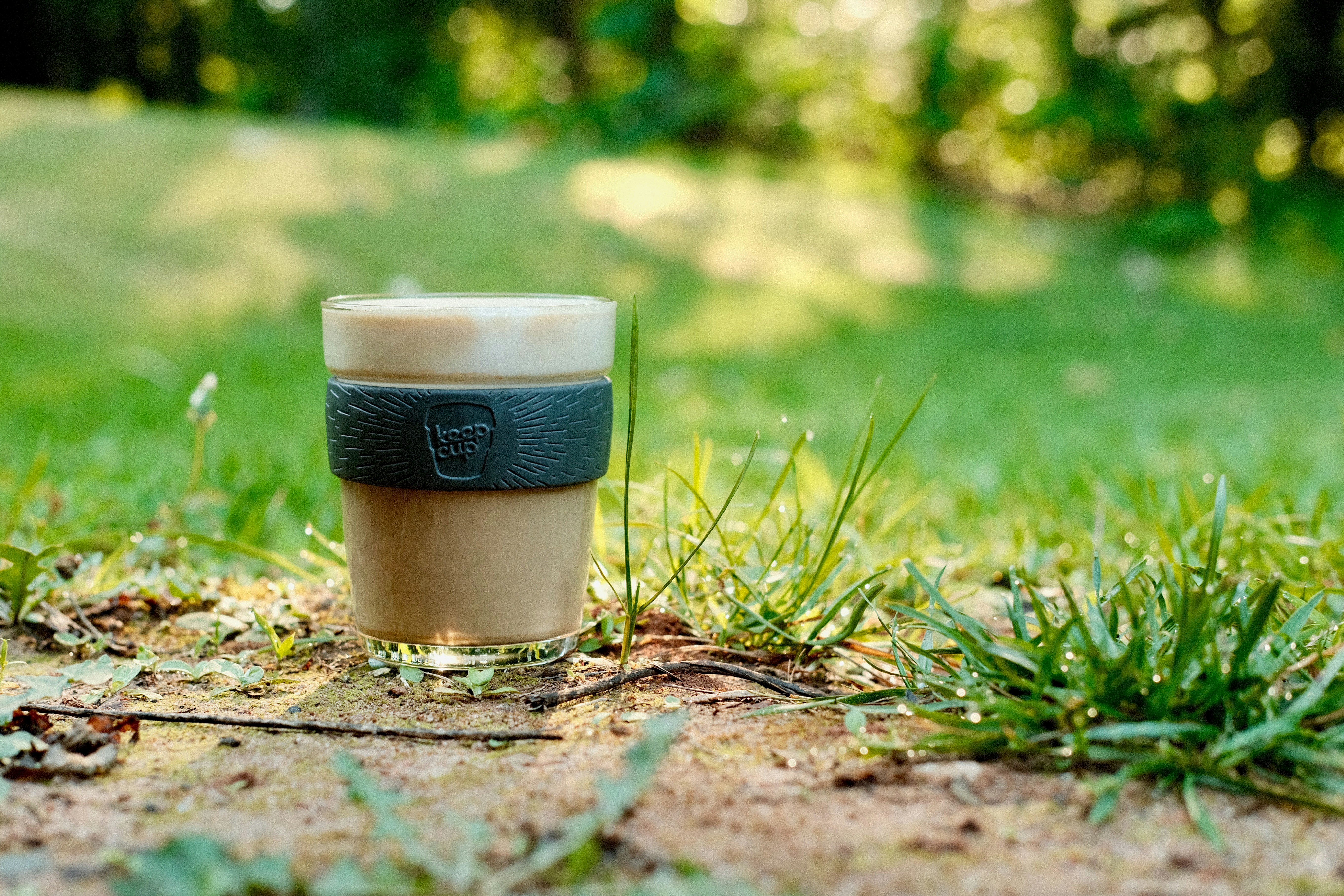 a cup of coffee sitting in the grass