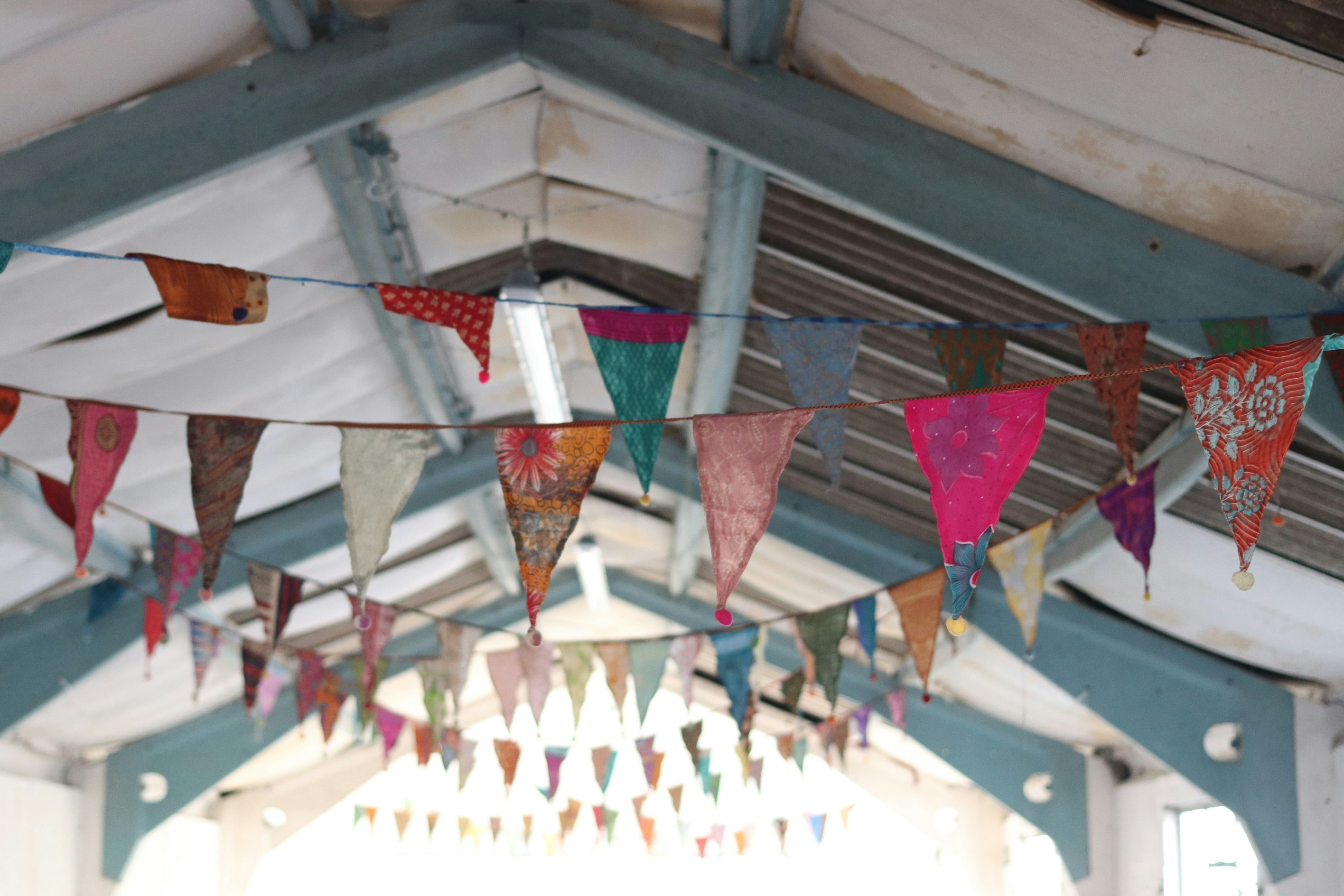 Colorful fabric bunting hangs from a ceiling